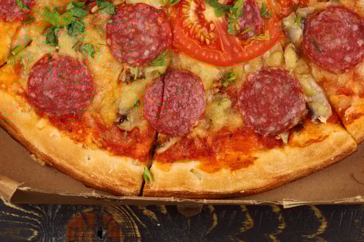 Pizza with sausage close-up. Pizza with Mozzarella cheese, salami, pepper. photo