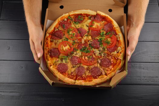 pizza in box open. Pizza in the in delivery box against a dark background photo