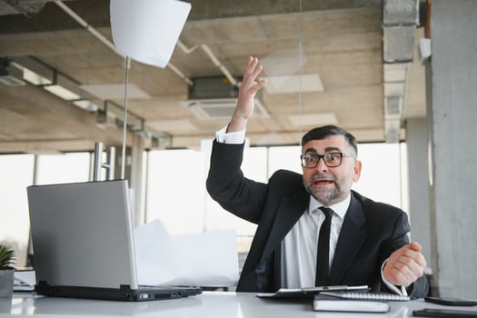 Angry businessman sitting at the table and screaming over. photo