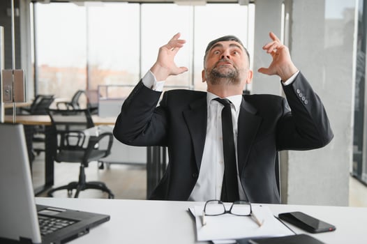 Angry businessman sitting at the table and screaming over. photo