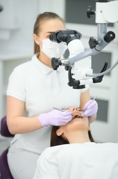 Beautiful young woman having dental treatment at dentist's office. photo