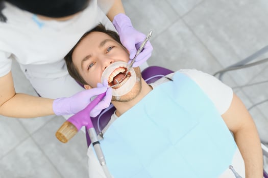 Young man at the dentist. Dental care, taking care of teeth. Picture with copy space for background. photo