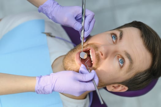 Man having a visit at the dentist's. Handsome patient sitting on chair at dentist office in dental clinic. photo