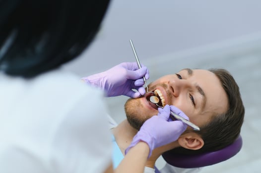 Young man at the dentist. Dental care, taking care of teeth. Picture with copy space for background. photo