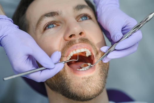 Young man at the dentist. Dental care, taking care of teeth. Picture with copy space for background. photo