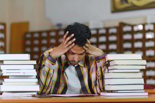 Clever arabian or indian male student or freelancer, in stylish casual clothes in the library photo