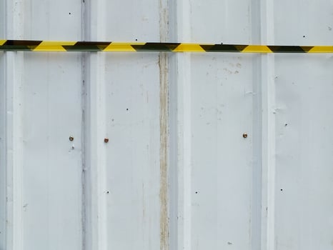 white corrugated metal plate with safety railing tape. Copy space for text. Outdoor industrial and construction concept background photo