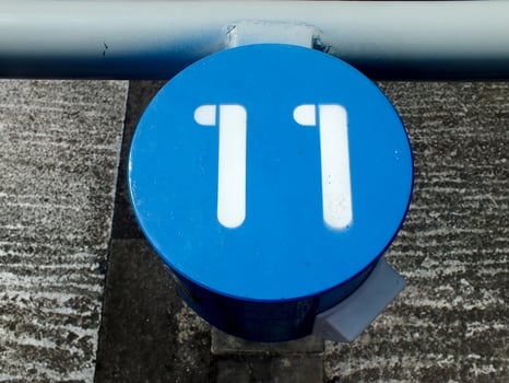 numeric number sign on blue round metal. The numeric is on white color. The object is on an outdoor area. photo