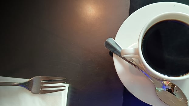 Black coffee in cup with spoon on table photo