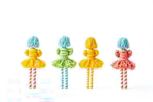 Four yarn dolls standing in a row photo