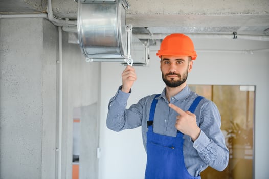 hvac worker install ducted pipe system for ventilation and air conditioning. copy space photo