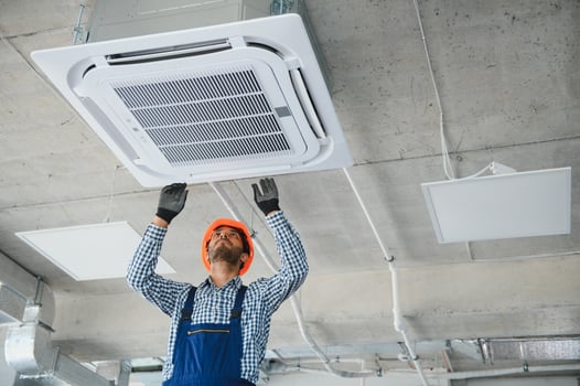 specialist cleans and repairs the wall air conditioner photo