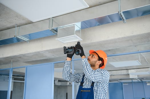 Professional technician maintaining modern air conditioner indoors. Space for text photo