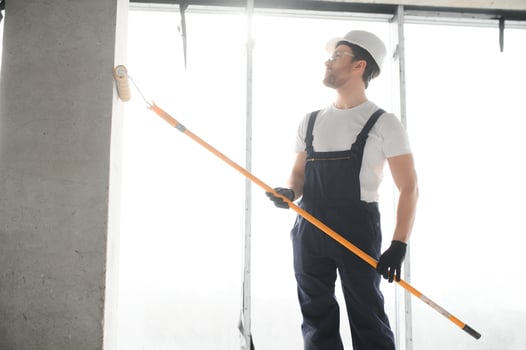 Worker renewing apartment on wall background. photo