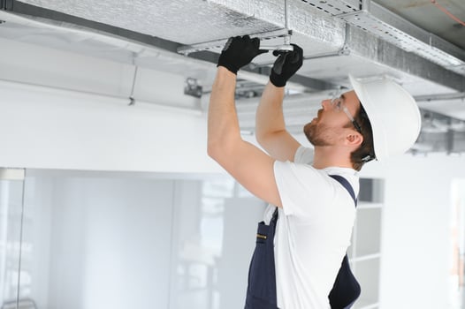 Caucasian HVAC Technician Worker in His 40s Testing Newly Installed Warehouse Ventilation System. Commercial Heating, Cooling and Air Ventilation Systems photo