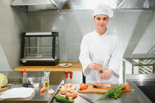 Portrait of young beautiful female chef in restaurant kitchen photo