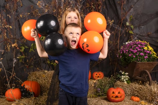 close-up portrait of happy, funny children holding a pumpkin on their heads. children playing preparation for halloween photo