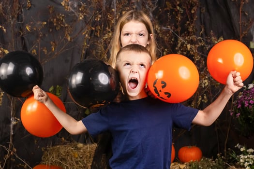 close-up portrait of happy, funny children holding a pumpkin on their heads. children playing preparation for halloween photo