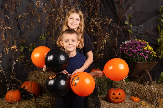 close-up portrait of happy, funny children holding a pumpkin on their heads. children playing preparation for halloween photo