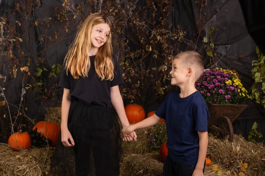 close-up portrait of happy, funny children holding a pumpkin on their heads. children playing preparation for halloween photo