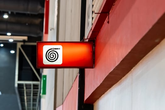 A fire equipment sign installed on a wall. Red light on to be noticeable in an exhibition hall that contains many participants. photo