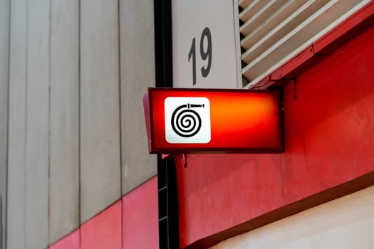 A fire equipment sign installed on a wall. Red light on to be noticeable in an exhibition hall that contains many participants. photo