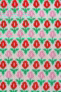 This cardigan fabric have a texture of geometric pattern with colourful red pink and green tulip flowers. photo