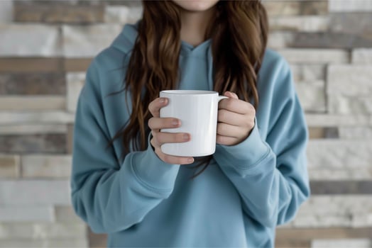 Girl in blue sweatshirt holding white coffee mug photo
