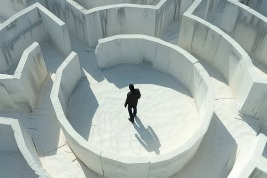 Aerial view of a businessman walking through a difficult maze made of white concrete walls photo