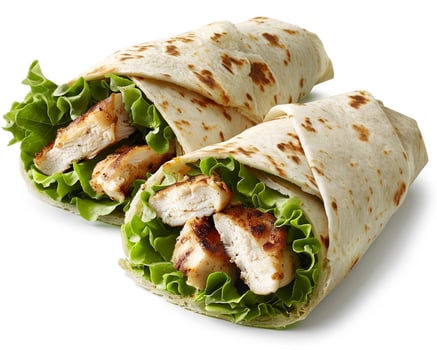 two chicken wraps with lettuce and tomatoes on a white background photo