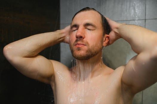 Handsoome man taking shower in modern bathroom photo