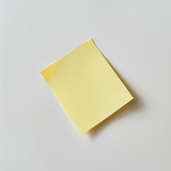 Blank yellow paper taped to the wall for writing messages. photo