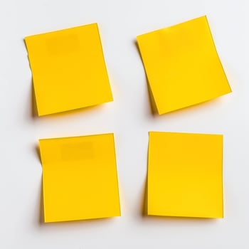 Blank yellow paper taped to the wall for writing messages. photo