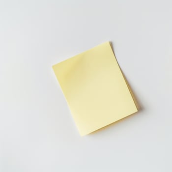 Blank yellow paper taped to the wall for writing messages. photo