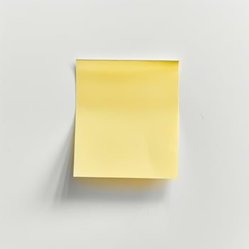 Blank yellow paper taped to the wall for writing messages. photo