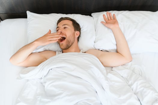 Happy young bearded man is relaxing on the bed at home photo
