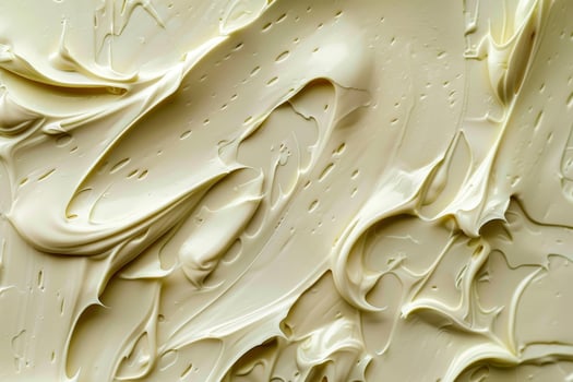 Closeup of a smooth and creamy beige texture with swirls and small droplets photo