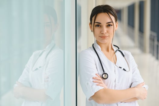 Happy young female doctor wear uniform, white medical coat, stethoscope. Portrait of beautiful female doctor, therapist, nurse. photo