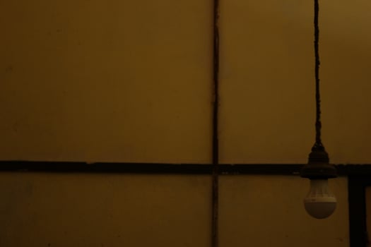 a person standing in front of a yellow wall with a sticker on it photo