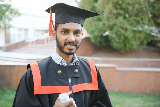 portrait of successful indian student in graduation gown. photo