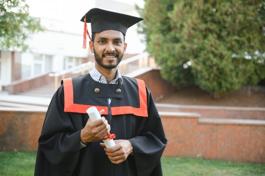 Handsome indian graduate in graduation glow with diploma. photo