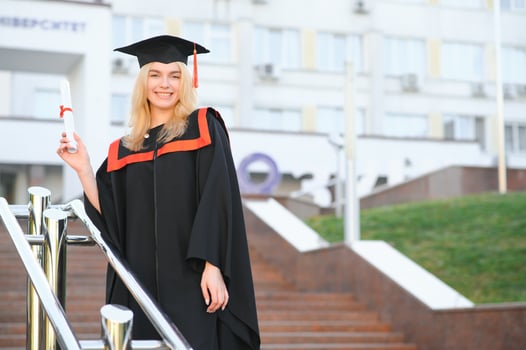 Happy graduation day for a young woman very beautiful with graduation cap smile large, while holding her diploma photo
