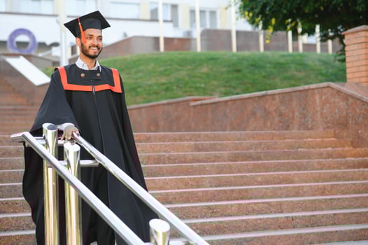 Portrait of indian handsome male graduate in graduation robe. photo