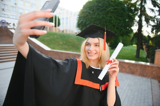 Young female student graduating from university take selfie photo