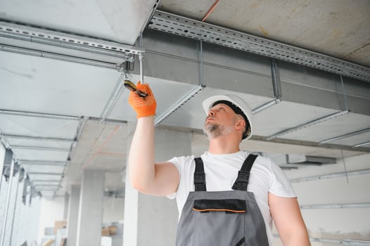 Man repairman. Master near ventilation pipes. Installation of ventilation for buildings. Man repairman with back to camera. Metal ventilation pipes. photo