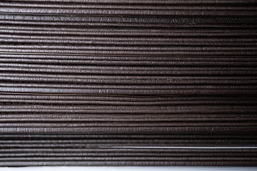 Stacked brown corrugated cardboard sheets close-up photo