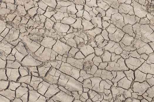 Dried cracked earth soil ground background texture. Top view photo