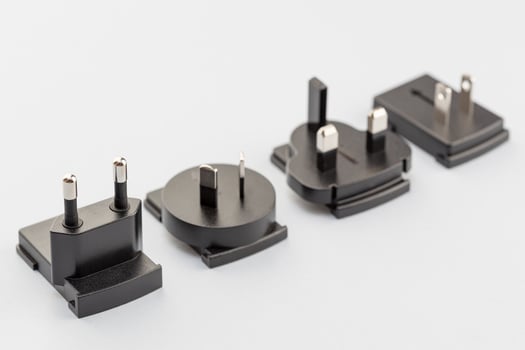 Variety of electrical plugs from different regions worldwide isolated on gray background photo