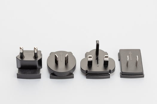Variety of electrical plugs from different regions worldwide isolated on gray background photo