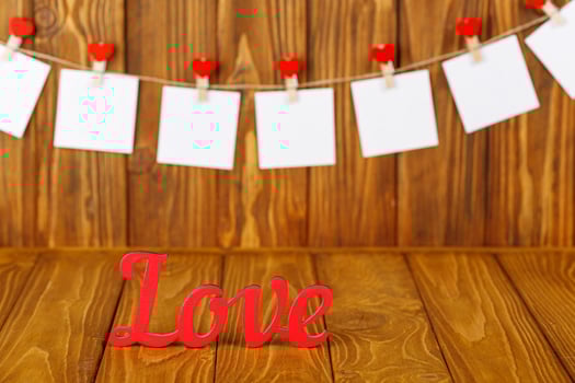 white pieces of paper on clothespins with a heart on a wooden background, a wooden inscription I love you photo